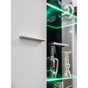 ויטרינה Solodo מבית רהיטי צ'אנס - תמונה של תאורה לצד דלת סגורה בצבע לבן מבריק עם ידיות כסף